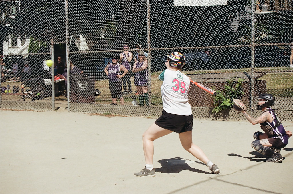 Softball player having just hit a ball.